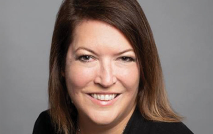 Professional woman with brown hair on grey background