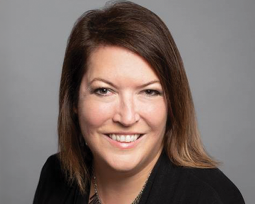 Professional woman with brown hair on grey background